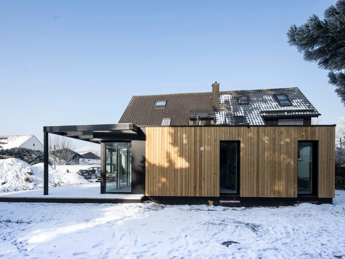 Seitenansicht von Anbau und Bestandshaus im Schnee