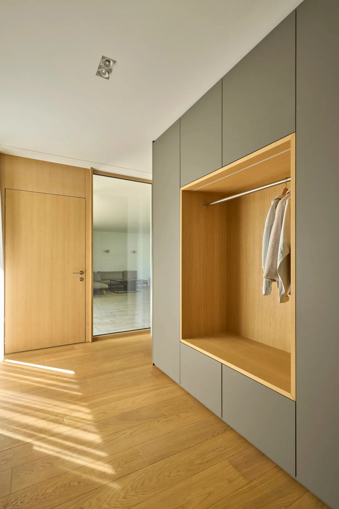 Flur mit Einbauschrank und Blick durch die Glastür ins Wohnzimmer