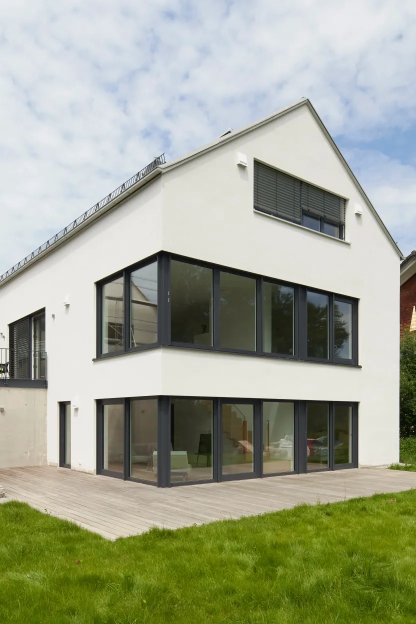 Straßenansicht mit Satteldach und dunklen Fensterrahmen