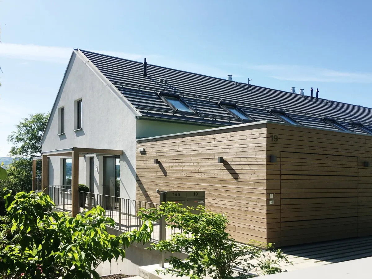 Eingangsseite mit Holzfassade und Carport