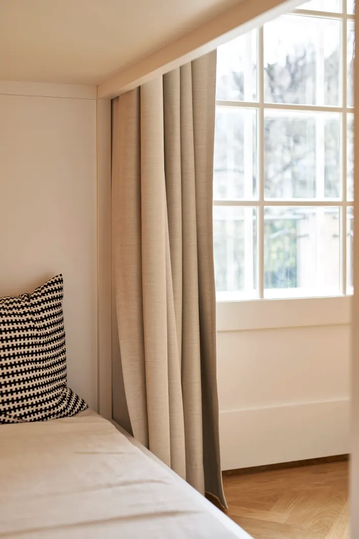 Fenster mit Vorhang und gemustertem Kissen