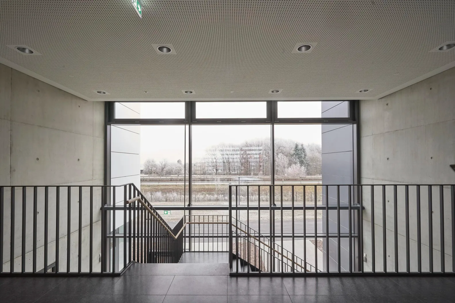 Treppenhaus mit Sichtbetonwänden und Blick ins Freie