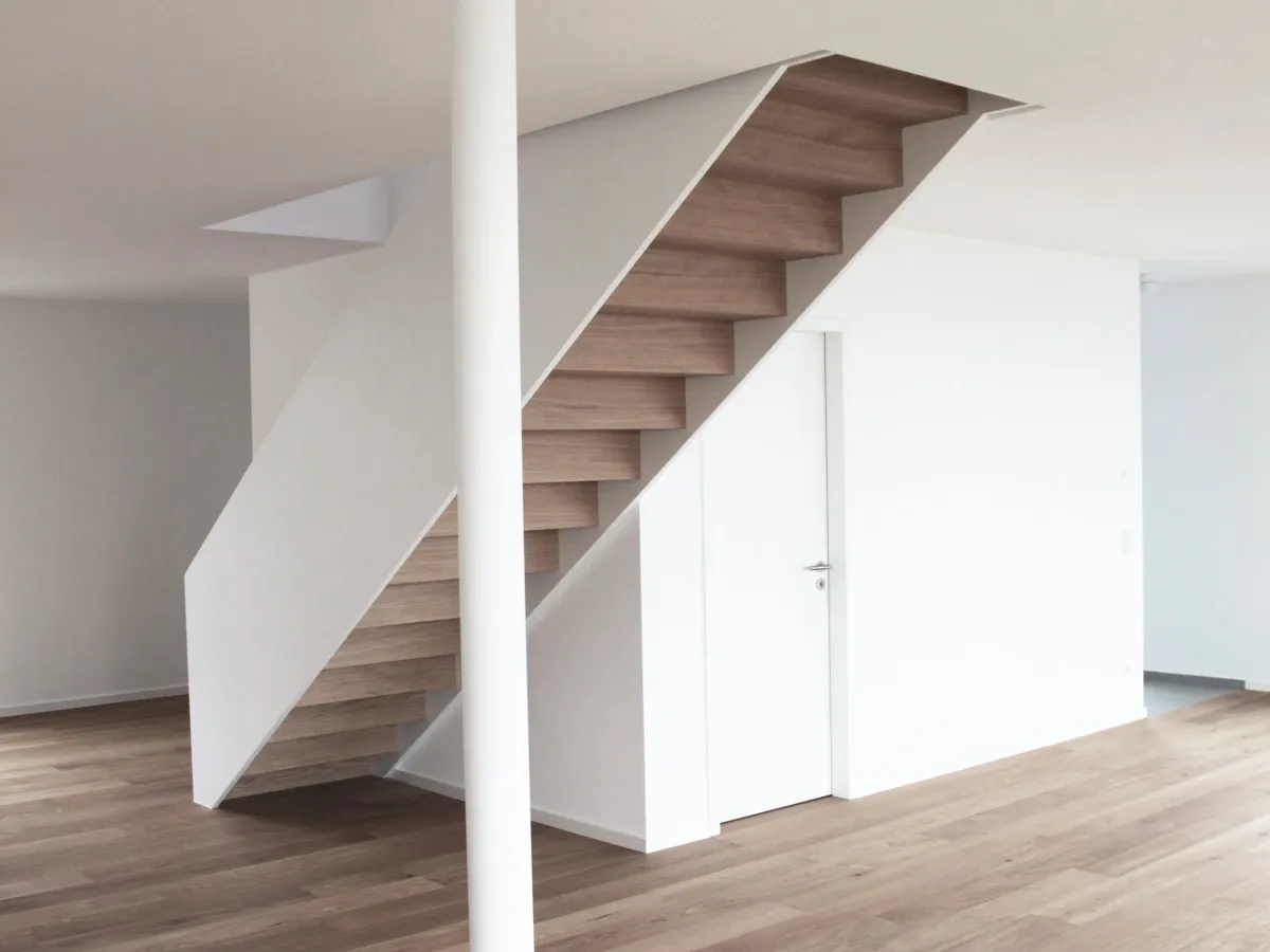 Wohnraum mit freitragender Holztreppe und schlanker Stütze