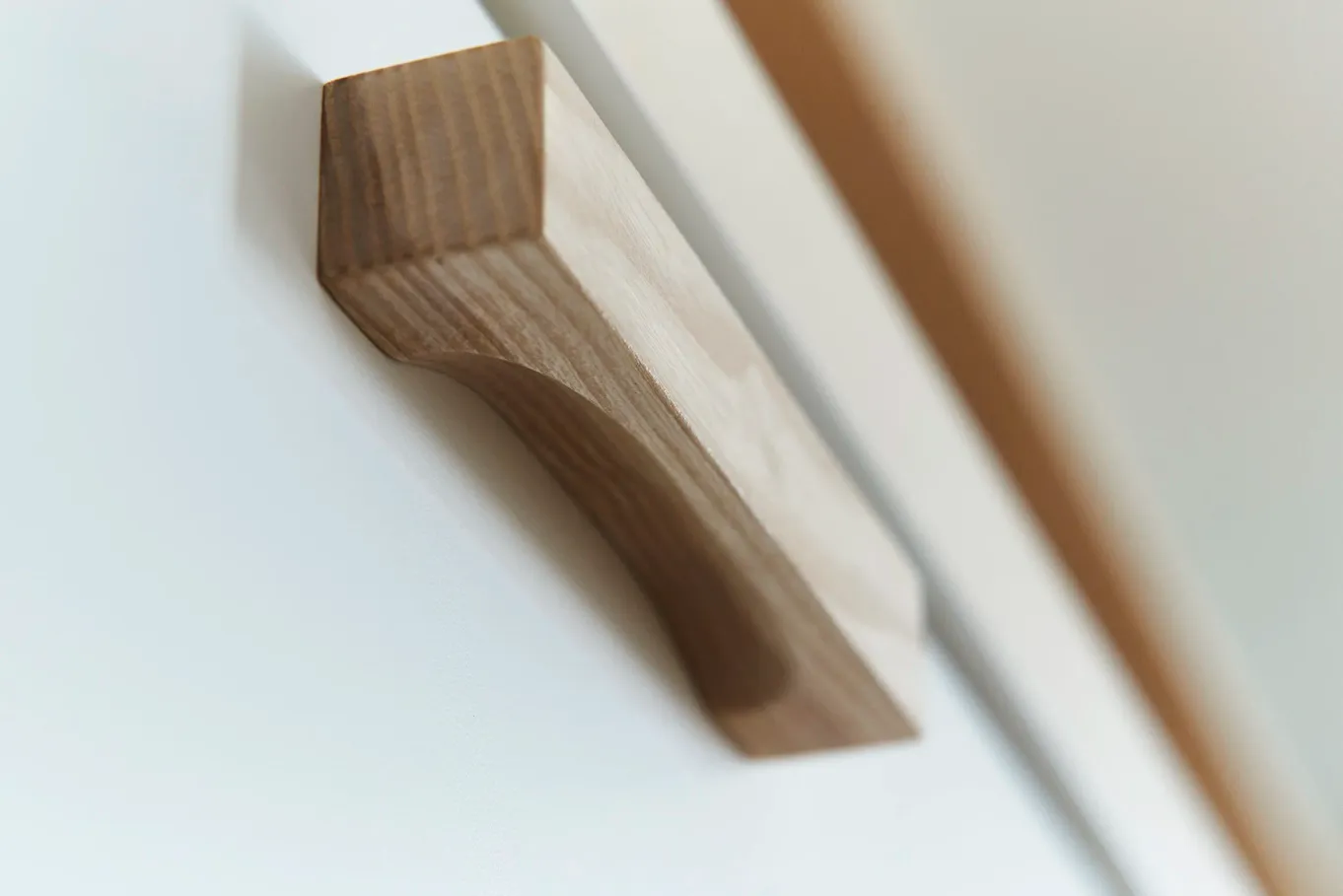 Holzgriff an weißer Schrankfront, Detail