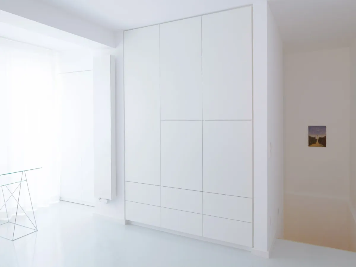 Weißer Raum mit Einbauschrank und Durchblick in ein Zimmer