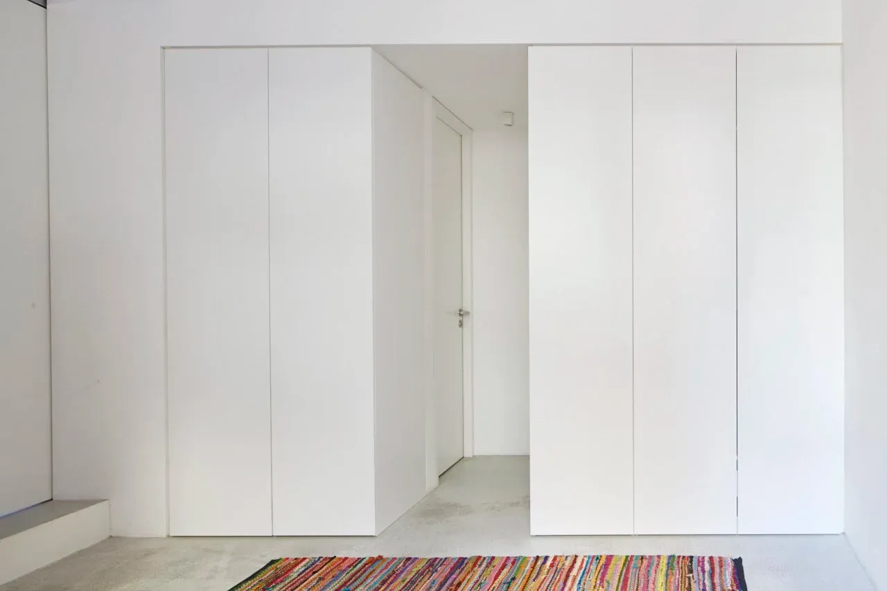 Einbauschrank im Flur mit bunt gestreiftem Läufer