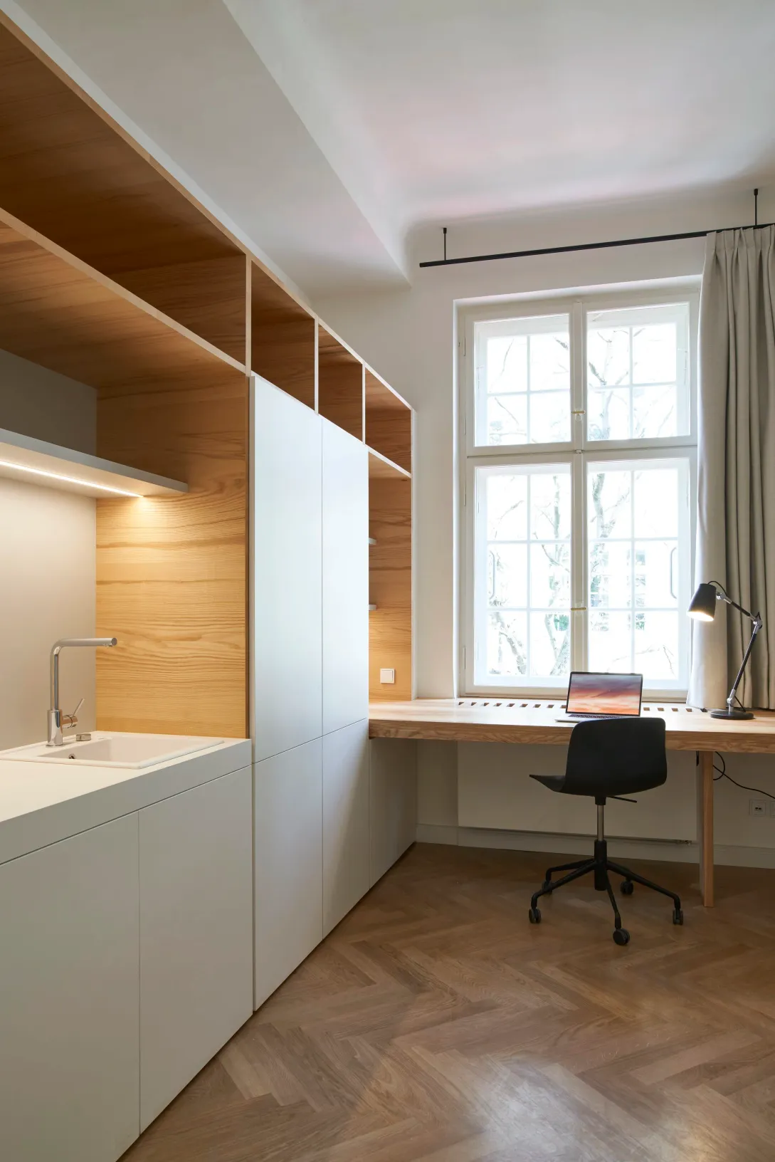Zimmer mit Kitchenette, Schreibtisch und Fenster