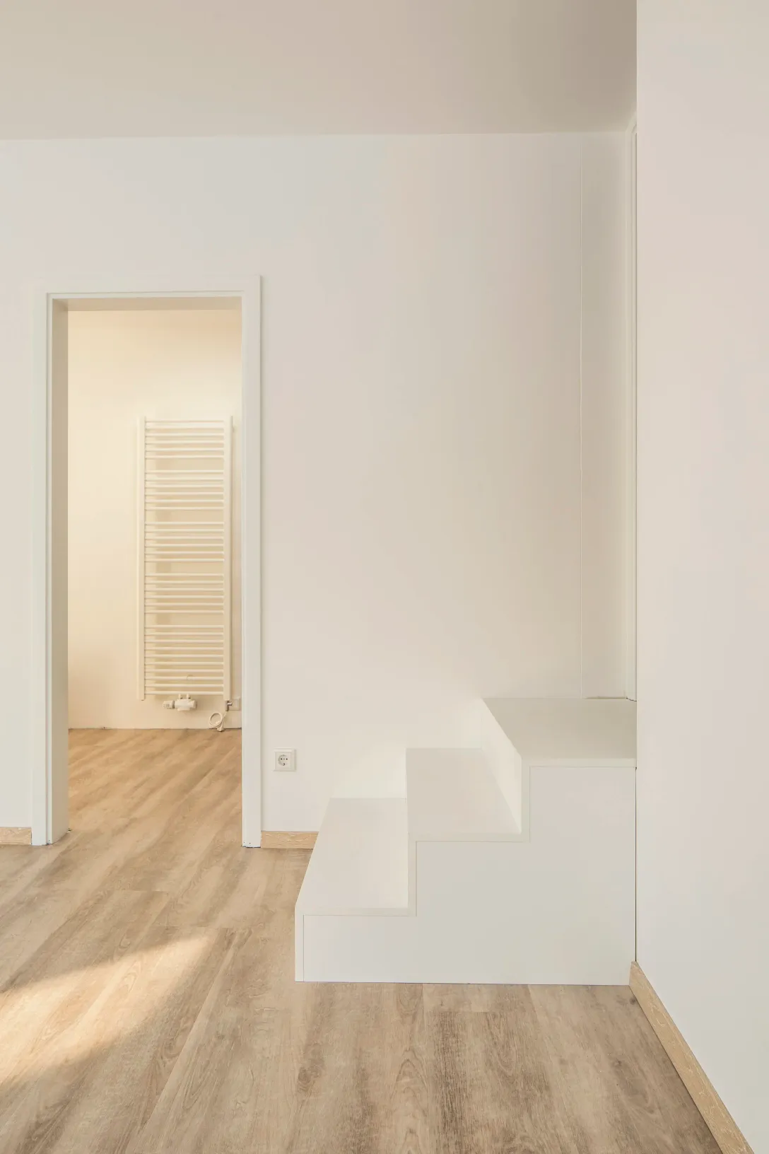 Minimalistische weiße Treppe zwischen Anbau und Bestandshaus