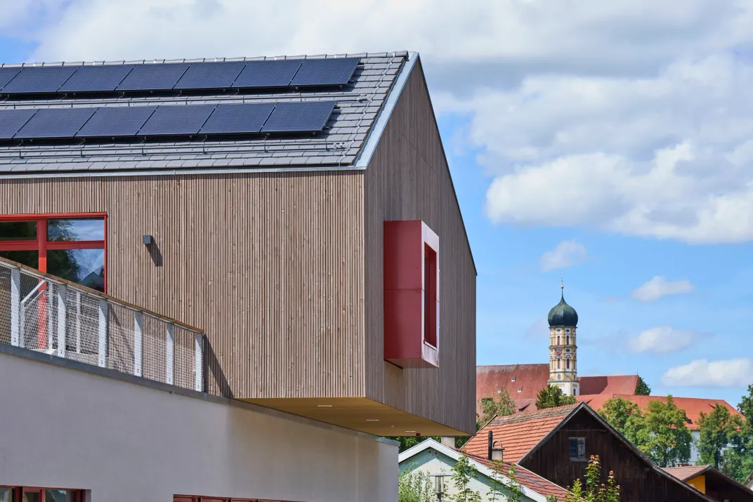Giebelfassade mit rotem Fenstererker, Blick zur Stadtpfarrkirche