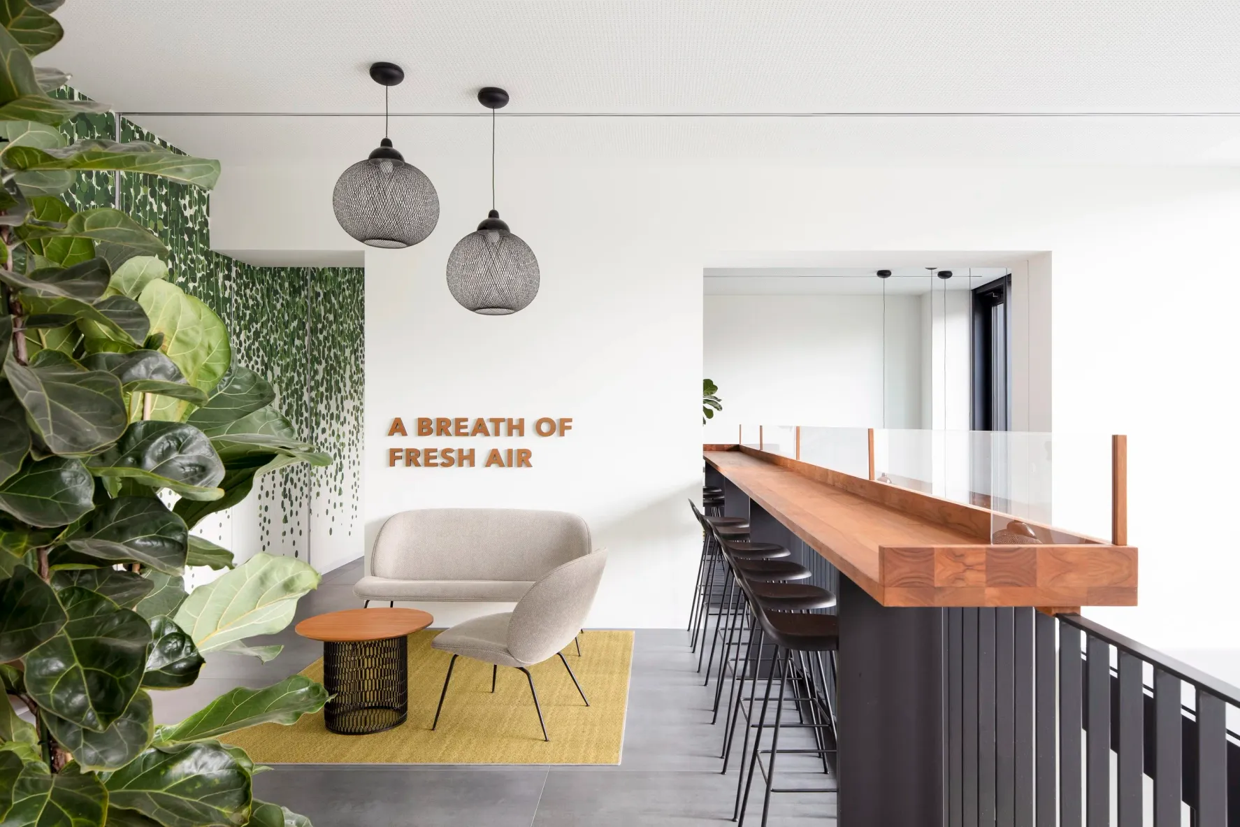 Dachgeschoss-Lounge mit Schriftzug „A Breath of Fresh Air“ und Bartresen